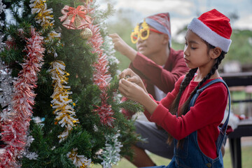 The children are celebrating Christmas and decorating the Christmas tree together.