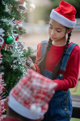 The children are celebrating Christmas and decorating the Christmas tree together.