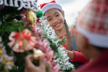The children are celebrating Christmas and decorating the Christmas tree together.