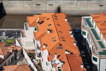 Residential houses with new clay tile roofs. View from above of white multi-storey buildings with beautiful orange clay tile roofs