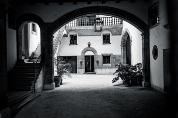 Historic courtyard with stone arches and soft lighting inside a traditional building. Elegant Mediterranean architecture.