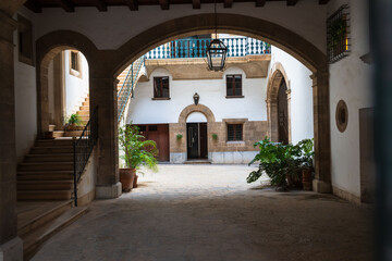 Historic courtyard with stone arches and soft lighting inside a traditional building. Elegant Mediterranean architecture.