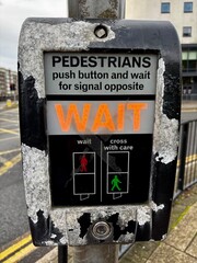 Teilaufnahme einer Fu&szlig;g&auml;ngerampel mit Hinweis in englischer Sprache; Warte