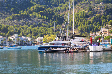 Coastal harbor with boats, green hills and blue water in a peaceful Mediterranean bay.