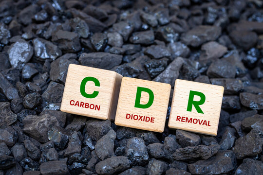 CDR on wooden cubes on a coal background. Environmental concept. Carbon dioxide removal. Close up