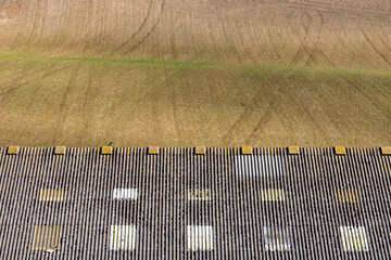 An abstract photograph of lines in farmland and a buildings roof