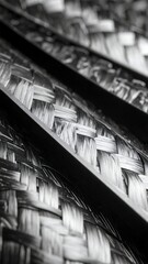 Close-up view of intricately woven carbon fiber material in monochrome.