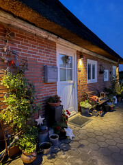 Cozy cottage entrance with thatched roof at dusk
