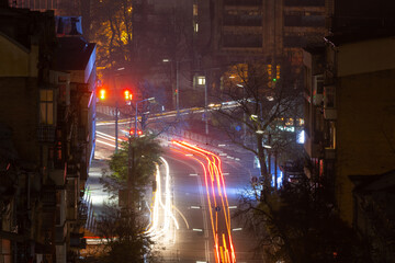Night city intersection with traffic light trails