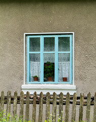 Rustic window on old cottage with wooden fence
