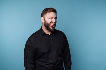 Obraz premium Man shows expression while standing against a blue background in a studio setting during daytime
