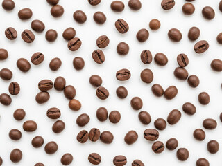 Obraz premium Scattered coffee beans on white surface
