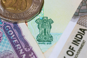 Close up view of Indian government emblem on colorful Indian Rupee bank notes.