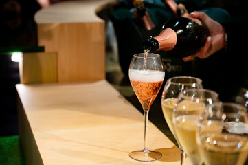 Pouring in glasses of french sparkling wine champagne with little bubbles, tasting wine, celebration, wedding or champagne tour with visit of caves, Reims, France