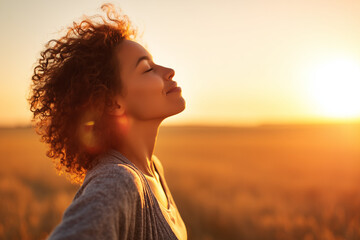 calm happy smiling free woman with closed eyes enjoys a beautiful moment life on the fields at sunset