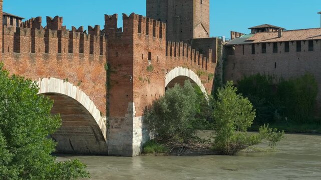 Castelvecchio bridge, a fortified bridge in verona, built on adige river by cangrande ii della scala in 14th century, is reflecting on the water under a clear sky