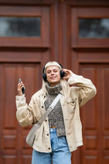 Blonde woman listening music on headphones urban lifestyle