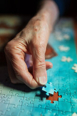 Elderly woman assembling a jigsaw puzzle