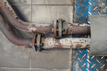 Rusted, worn pipes and flanges of an exhaust system, removed for replacement. Professional repair, maintenance, and diagnostics of the car's muffler and catalytic converter.