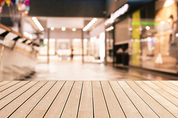 Empty wooden table against blurred view of shopping mall. Space for design