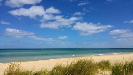 Melbourne, Australia - 25 December 2017: Bonbeach Sand and Sailboat. Coastal Grass, Calm Sea and...