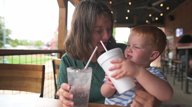 parent and child engage in playful science activity, joyful family moment with colorful drinks and string lights, lively family scene of mother and child conducting amusing pouring task