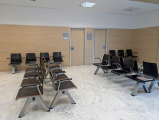 Modern spacious hospital or clinic patients waiting room area with empty chairs. Clean and illuminated medical facility, healthcare, health, contemporary interior architecture, comfort, tranquility.	