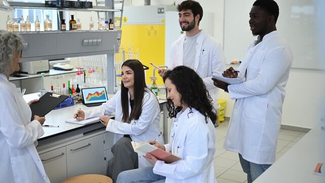 University professor teaching science students in a modern laboratory