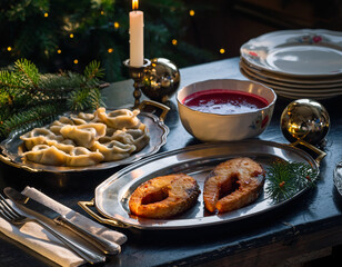 Stół wigilijny ze smażonym karpiem, pierogami i czerwonym barszczem. Tradycyjna, polska kolacja wigilijna
