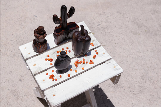 Artisanal wooden chiltepineros and scattered chiltepin peppers