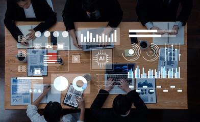 A diverse team engages in data analysis and brainstorming in a modern office, utilizing technology and visual aids to enhance their strategic business discussions. Gantry