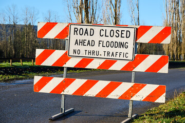Road Closed sign warning flooding ahead no thru traffic on rural road