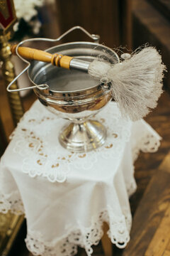 Holy water font and aspergil during christian baptism ceremony
