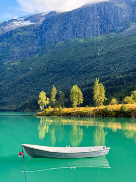 White boat floating on turquoise loen lake in stryn, norway