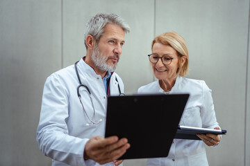 Medical professionals collaborating on digital tablet for healthcare data