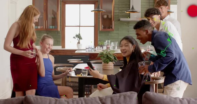 Seated woman turning phone toward social group sharing clip, friends leaning in and icons moving