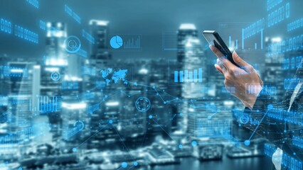 A businessman interacts with a smartphone surrounded by a digital data overlay, showcasing urban innovation and technology trends in a bustling city at night. Xenic