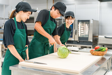 Kitchen, male and female cooks cutting cabbage in the back yard