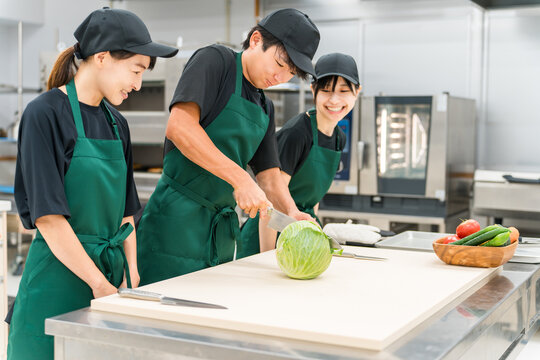 Kitchen, male and female cooks cutting cabbage in the back yard