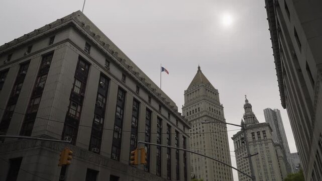 Looking Up Historic Urban Buildings With Flag, Stone Facades Rise Into Overcast Sky, Narrow Street Canyon Framing Landmark Tower, Muted