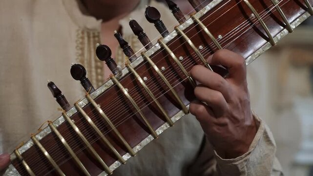CloseUp Sitar Hands Plucking Strings In Intimate Home Studio, Session Musician Practicing Raga Phrases On Ornate Instrument, Warm Natural