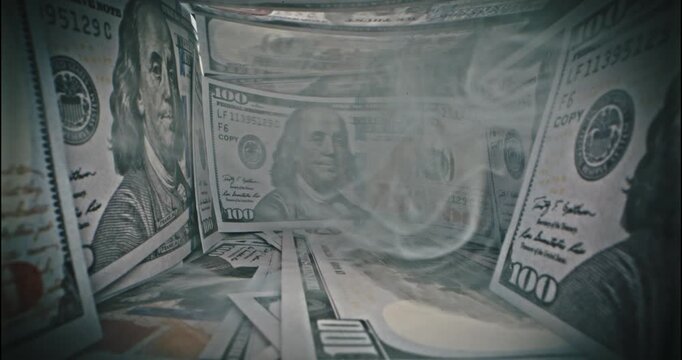 Close-up macro view of scattered US 100 dollar bills in dramatic lighting, symbol of wealth, finance, business success and US economy