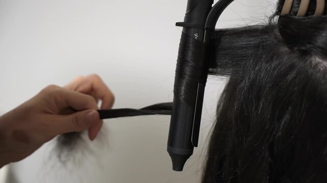 Stylist Curling Long Hair With Curling Iron CloseUp Hands Wrapping Section, Salon Tools Visible, Focused Technique And Finish