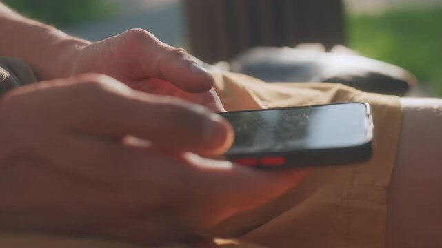 Closeup Caucasian Hands Holding Phone, Sunlit Park Bench Scene With Thumb Scrolling Glossy Screen, Notification Light Pulsing, Repetitive Tapping And Tense Gestures Imply Anxiety, Paranoia