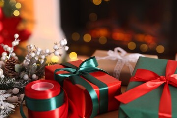 Beautiful Christmas gifts and festive decor on table indoors, closeup. Bokeh effect