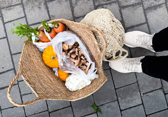 Person carrying fresh groceries in ecological bag on street