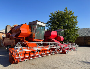 Red combine harvester parked on farm, preparing harvest