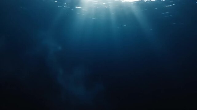 Sunlight beams pierce deep ocean blue abyss, underwater, cinematic light rays shimmering through dark water, peaceful serene seascape