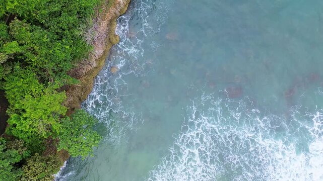 Top Down Drone View of Ocean Waves Crashing on Rocky Coast, Ngliyep Beach Indonesia