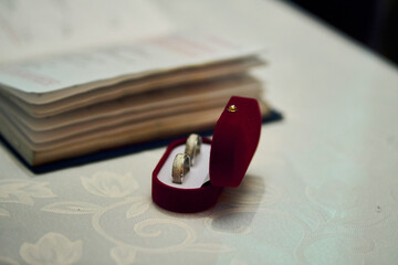 A glimpse of a couple renewing their vows, exchanging rings, a view of rings in a marriage, placing them on their fingers, alongside a priest, at a wedding celebration. Love, ritual, togetherness.